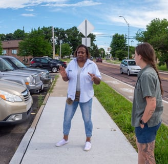 Sophia talking to two young people while standing on a sidewalk