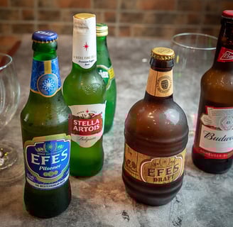 a variety of beer bottles and glasses on a table