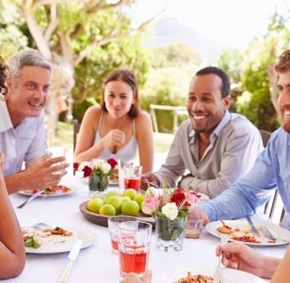 people gathering around a picnic table having a fun discussion
