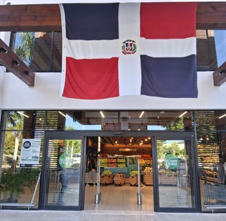 Dominican Republic supermarket entrance with fresh produce and national flag above the door 