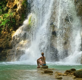 Woman relaxing at El Limón Waterfall surrounded by lush jungle in the Dominican Republic