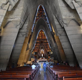 Interior view of Basílica de Higüey with stained glass and unique concrete arches