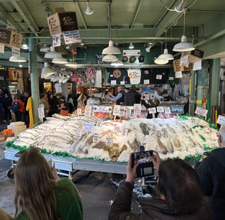 Pike Place Fish market, with a large open cooler full of ice and whole fish