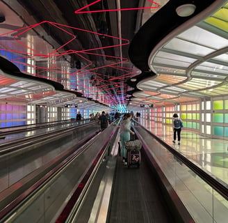 a group of people walking down a long escalator