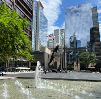 A fountain in front of skyscrapers