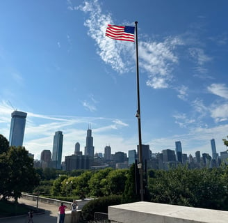 A United States flag with the Chicago city skyline in the background