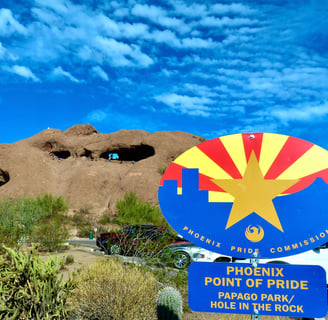 a sign that says phoenix point of pride Papago park/ hole in the rock in front brown rocks