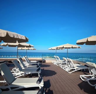 lounge chairs and umbrellas on a deck deck from H10 Costa Adeje Palace hotel