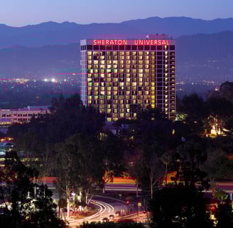 a city skyline view of Sheraton Hotel on a neon sign 