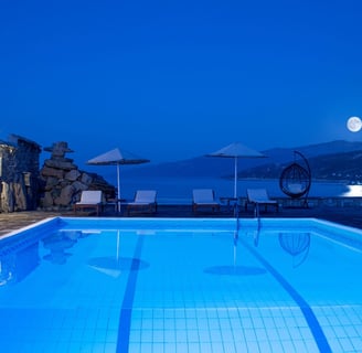 a pool with a moon in the sky Cavos Bay Hotel