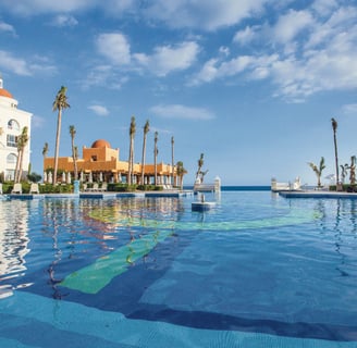 a pool with a view of the ocean from Riu Palace Cabo San Lucas