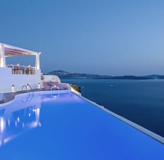 a pool with a view of the ocean from Katikies Hotel Santorini