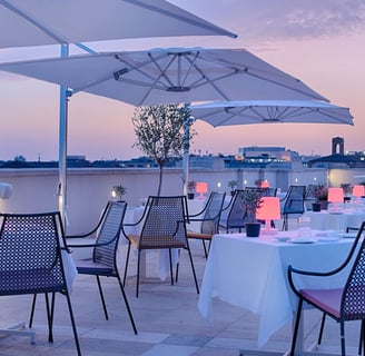 a restaurant with tables and umbrellas on a roof top