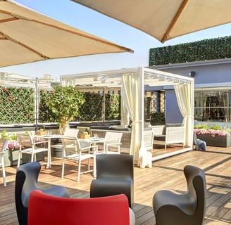 a patio with a table and chairs and umbrellas