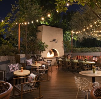 a patio with a fireplace and outdoor seating area from The Garland Hotel