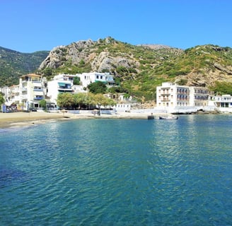 a beach with a mountain in the background Anthemis Hotel
