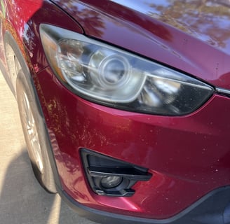 before image of shiny red car's headlight