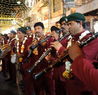 Crew members of the Manohar Brass Band playing clarinet, shehnai, and thap dhol instruments during a traditional performance.
