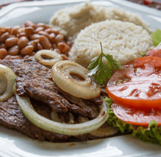 a plate of food with steak rice beans and vegetables (vistec encebollado)