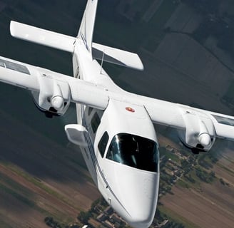 a white airplane flying over a field