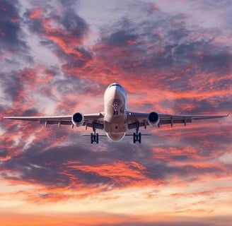 a plane taking off into the sunset