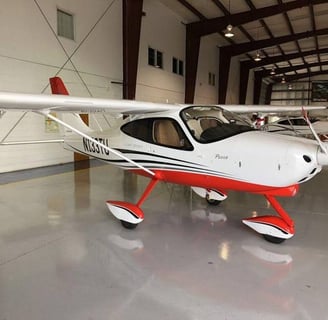 a small plane in a hangar with a red and white stripe