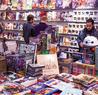 a bunch of people standing around a table with a lot of toys