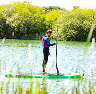 A Man Paddleboarding on a River
