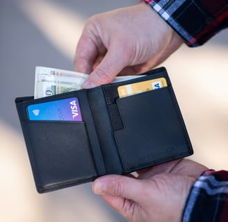 a person holding a wallet with a credit card