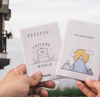 two people holding up their passport cards with a mountain view