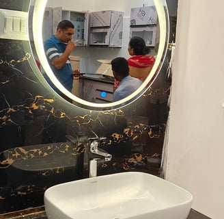 a bathroom sink with a mirror and a man in the mirror