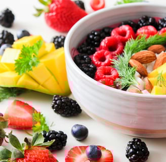 a bowl of fruit and nuts on a table
