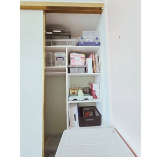 The transformed cupboard with organised shelves and labelled storage boxes