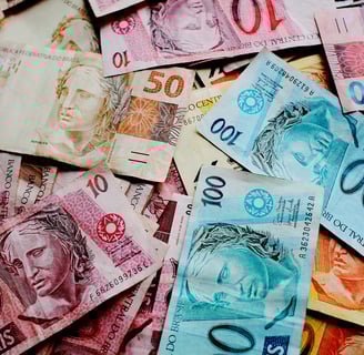 cédulas de reais em ci,a de uma mesa 