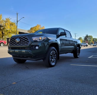 a green toyota tacoma sei truck parked in a parking lot