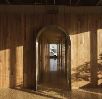 Wood-paneled clinic hallway with archways and city view – Fertilidad Integral in Mexico.