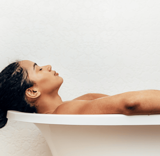 Woman relaxing in bathtub as part of fertility self-care routine