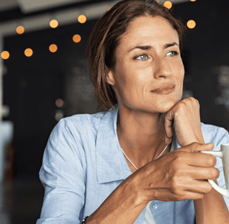 Woman sipping coffee and reflecting on fertility journey