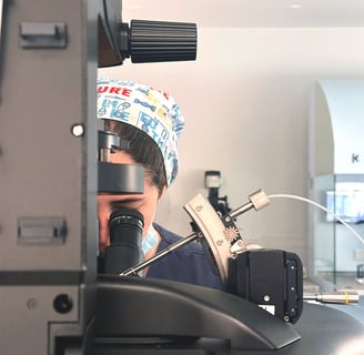 Fertility specialist conducting lab analysis under a microscope