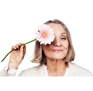 uma senhora segurando uma flor recebendo dicas para o tratamento da menpausa