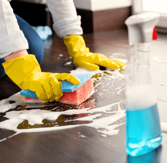 a person cleaning a wooden floor with a sponge pad