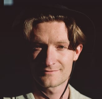 tristan lyons wearing a bucket hat with the sun shining on his face