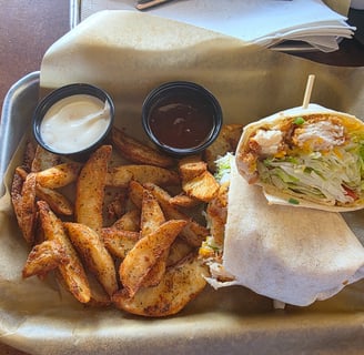 buffalo ranch chicken wrap with potato wedges., a side of ranch and honey bbq sauce from Bdubs