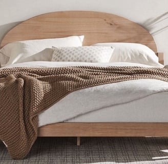 neutral tan bed frame, brown throw blanket, white comforter, neutral paint
