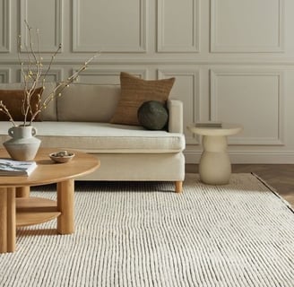neutral living room with neutral coffee table, pillows and couch