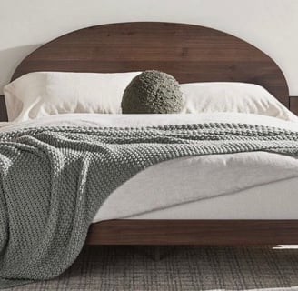 neutral brown bed frame with grey throw blanket and a accent pillow, with neutral paint, plaid rug
