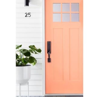peach painted front door with black hardware 