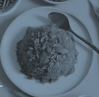 a plate of rice with a spoon and spoons