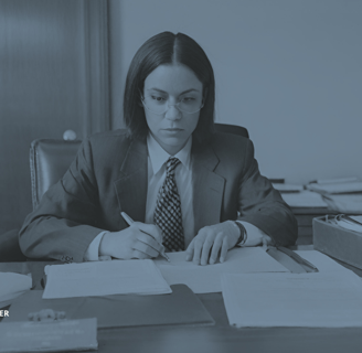 a woman in a suit and tie is sitting at a desk