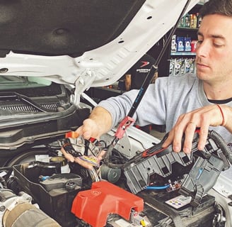 un hombre con una camisa gris está trabajando en un auto